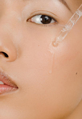 model dropping serum onto her cheek