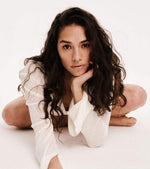 Woman in a white outfit sitting on a white background