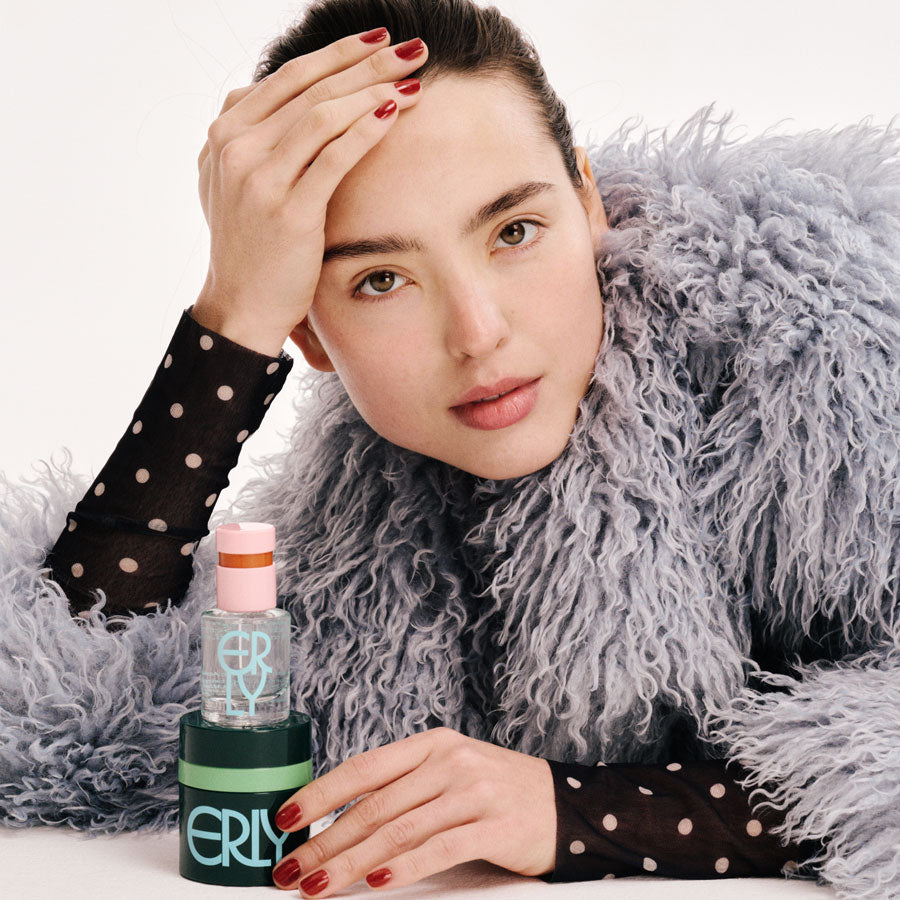 brunette girl with polka dot and fur, red nails and skincare products
