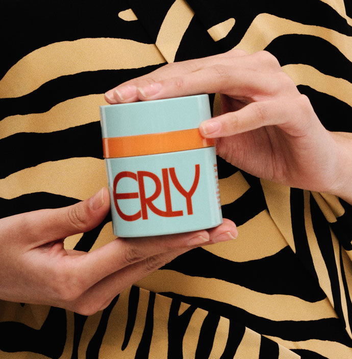 ERLY Start Moisturizer SPF 40 being held in front of a zebra dress with two hands