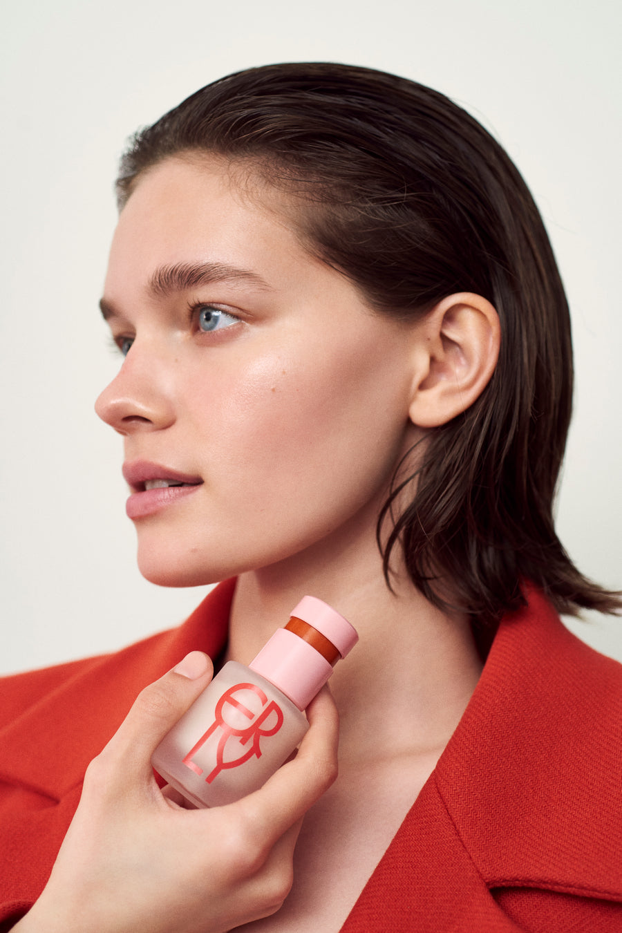 Daily Dew Illuminating Serum on model in red jacket.