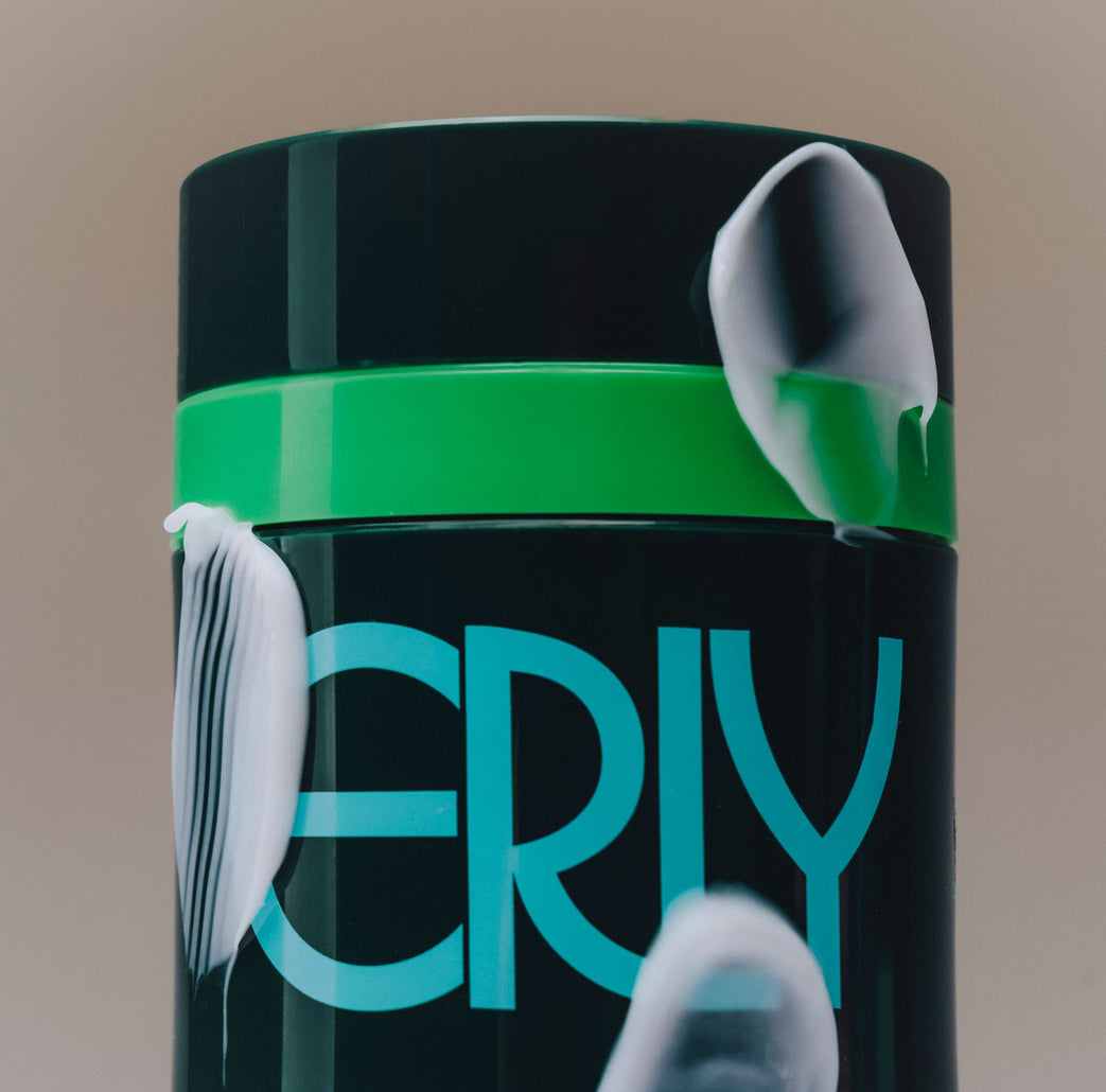 A close up of ERLY Night Moisturizer green bottle with blue writing and the product on the outside 