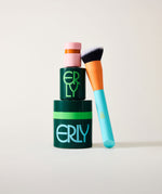 Two makeup containers and a brush with 'ERLY' branding on a light background