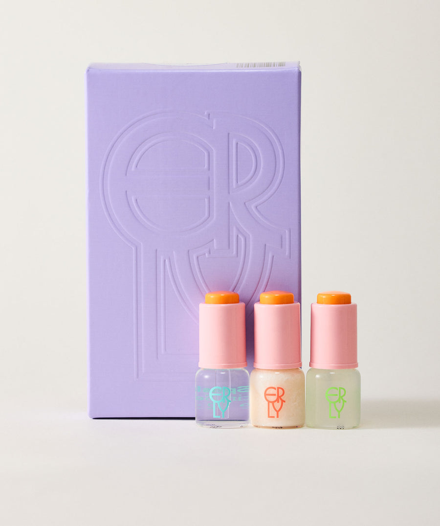 Three small bottles with colorful caps in front of a purple box with a logo on a white background