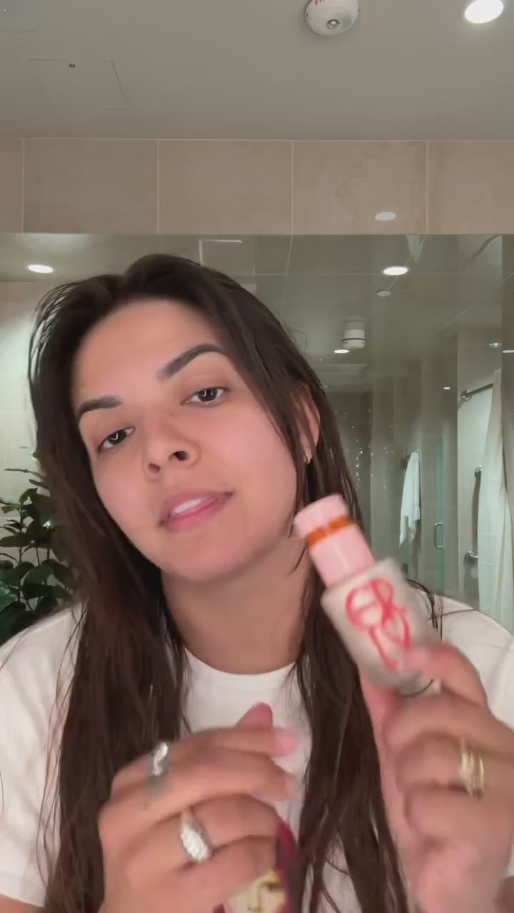 Brunette woman applying ERLY Daily Dew Illuminating Serum 