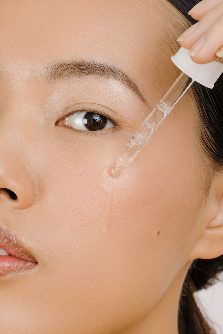 Model putting serum on her face